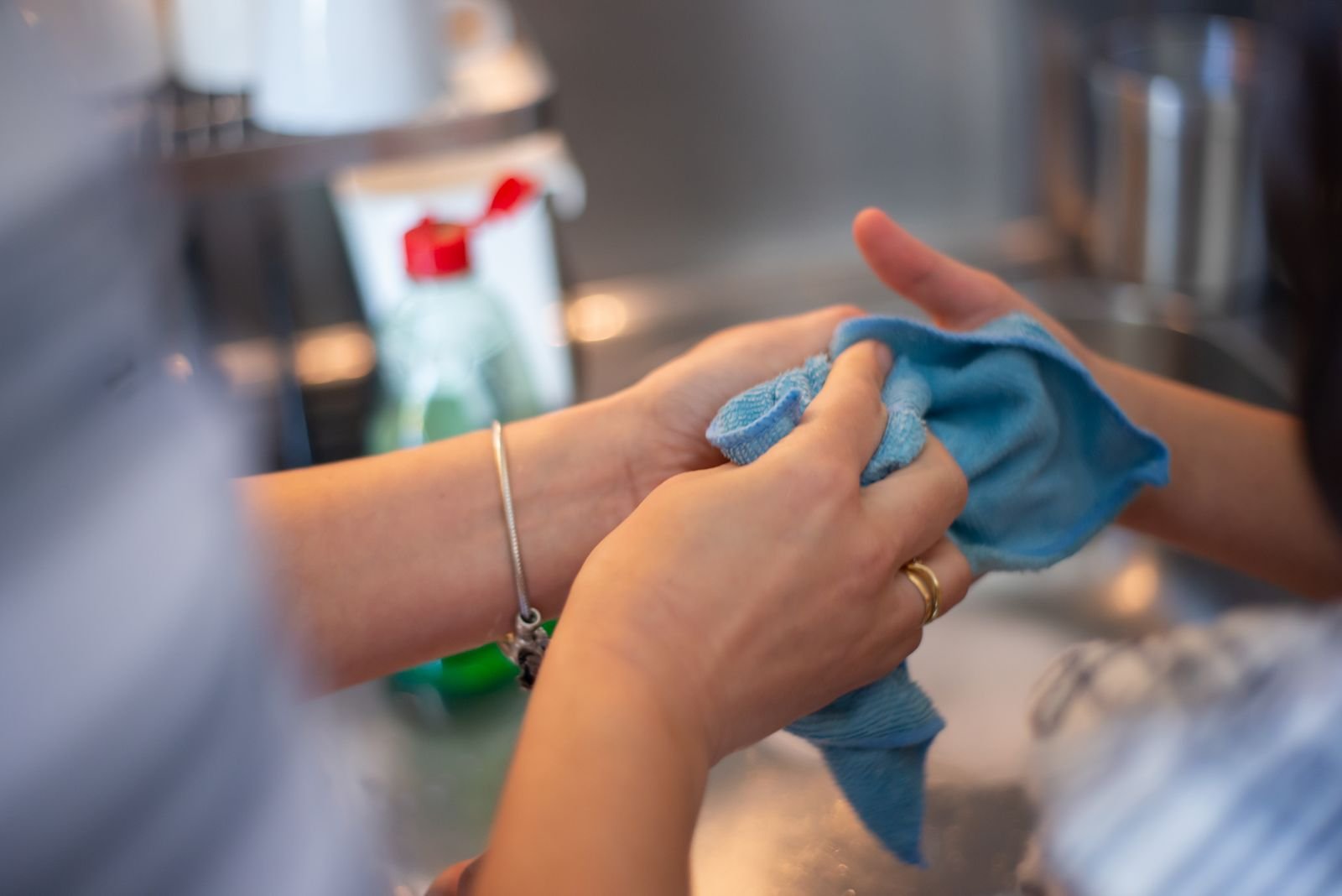 Cleaner spraying a cleaning solution while preparing to wipe down a surface