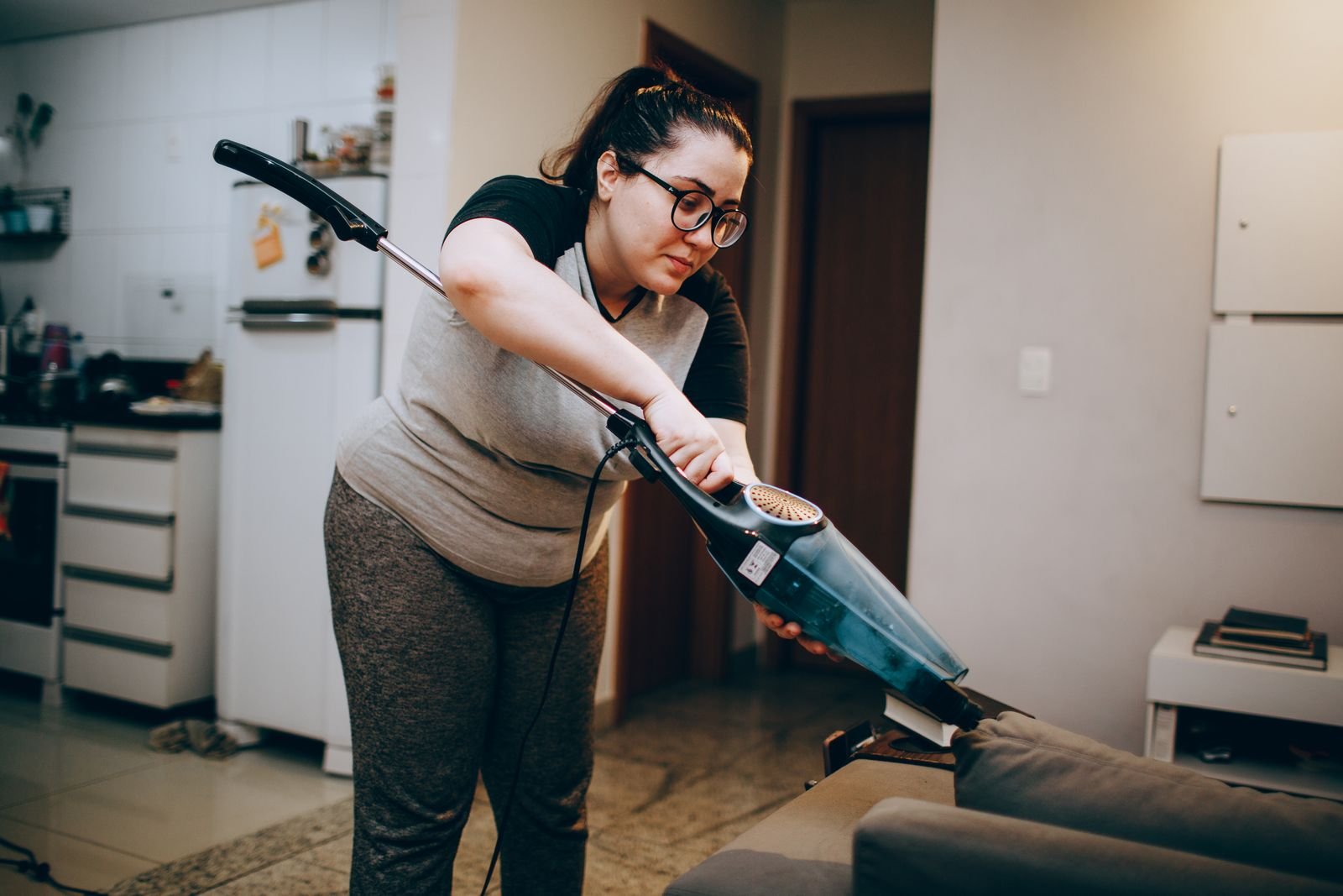 Professional cleaner tidying a bright kitchen worktop in a UK home